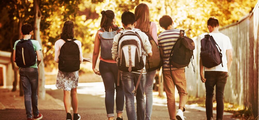 Partnerschaft für Demokratie des Landkreises Görlitz Einer Gruppe Kindern mit Schulranzen (Rückenansicht) auf dem Schulweg