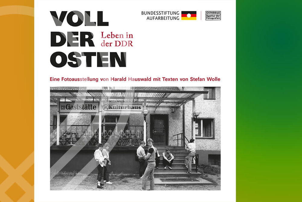 News - Plakat der Fotoausstellung von Harald Hauswald mit Texten von Stefan Wolle mit dem Titel „Voll der Osten. Leben in der DDR“. Zu sehen ist ein schwarzweiß Foto aus der DDR mit einer Gruppe von Jugendlichen vor einer Gaststätte.